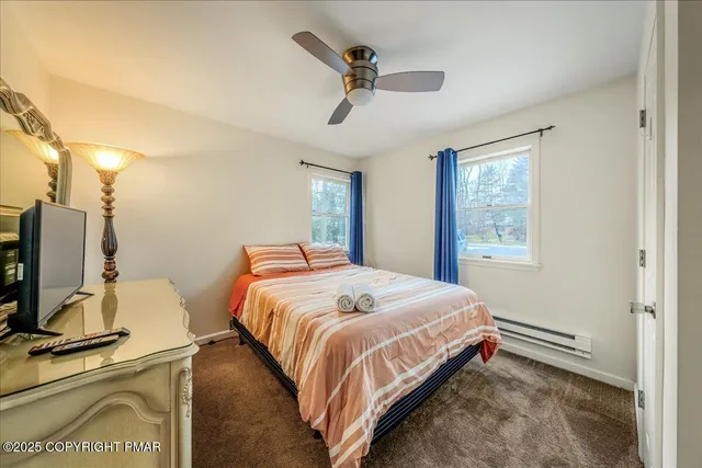 a bedroom with a bed flat screen tv and a window