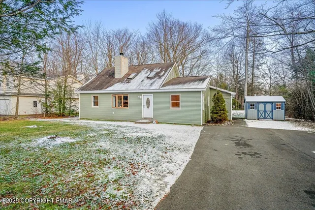 a front view of a house with a garden and trees