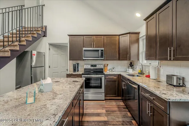 a kitchen with stainless steel appliances granite countertop a sink stove and refrigerator