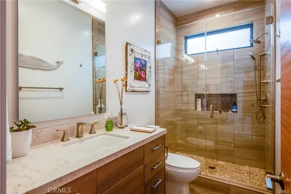 a bathroom with a granite countertop sink a toilet and shower