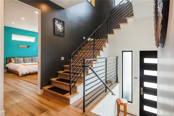 a view of entryway bedroom and hall with wooden floor