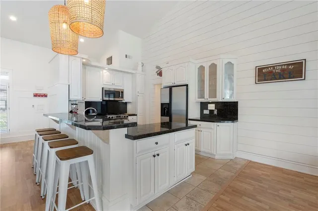 a kitchen with a dining table chairs and view of living room