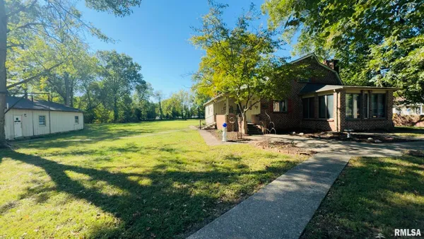 a view of a house with backyard and tree