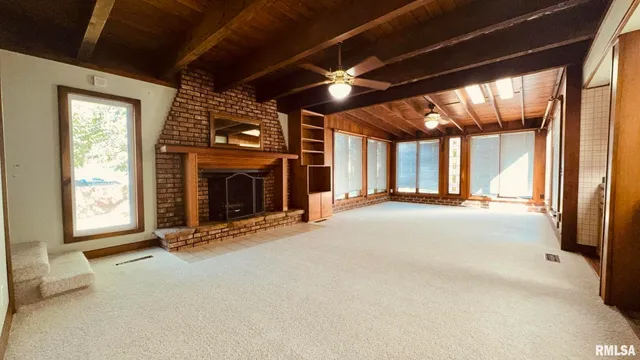 an empty room with fireplace and windows