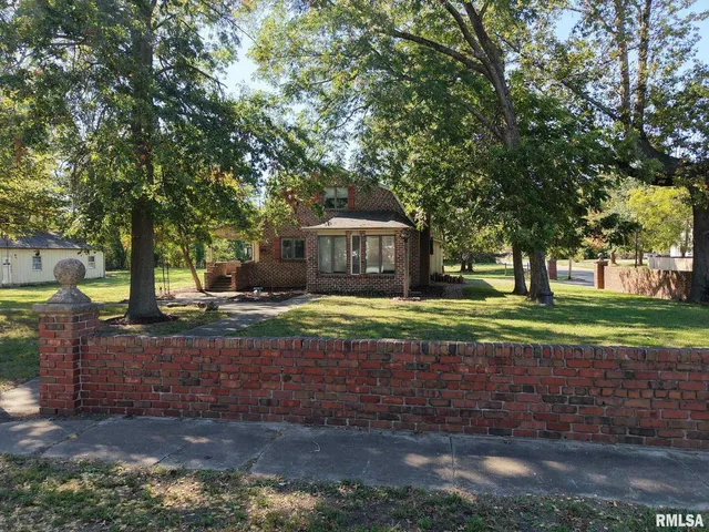 a view of a house with backyard and tree