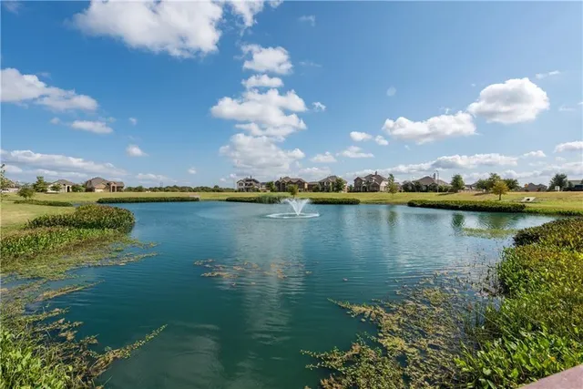a view of a lake with houses in the back