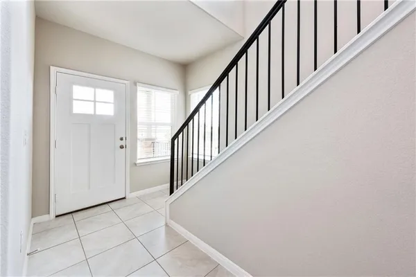 a view of staircase with railing and white walls