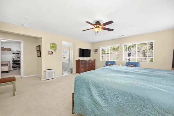 a spacious bedroom with a bed and a dresser in it