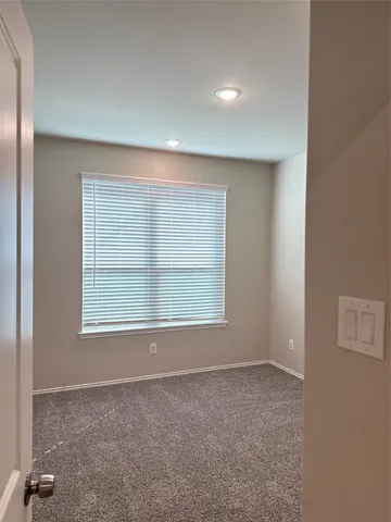 an empty room with a chair and a window