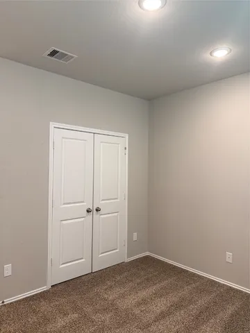 an empty room with white wall and closet