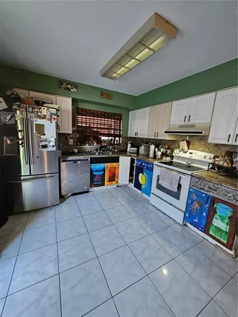 a kitchen with stainless steel appliances granite countertop a refrigerator oven a sink dishwasher and a stove