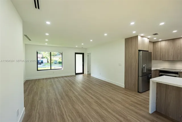a view of kitchen with refrigerator and window