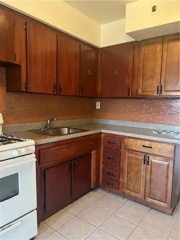 a kitchen with stainless steel appliances granite countertop a stove a sink and a refrigerator with wooden cabinets