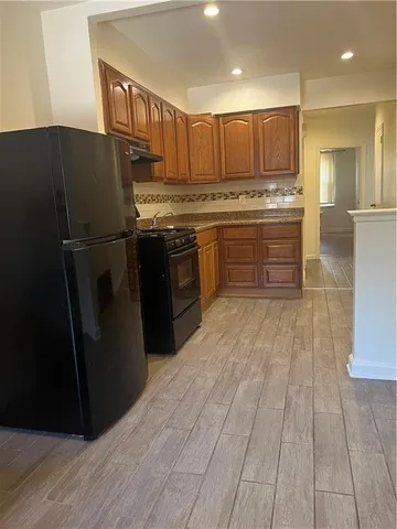 a kitchen with stainless steel appliances granite countertop a refrigerator a sink and a stove