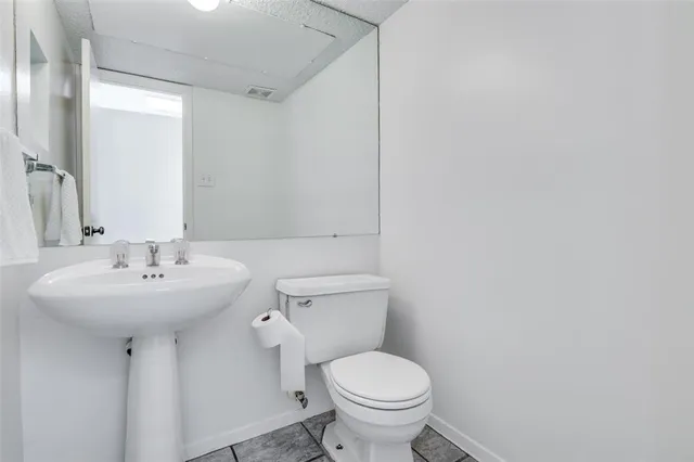 a bathroom with a sink toilet and mirror