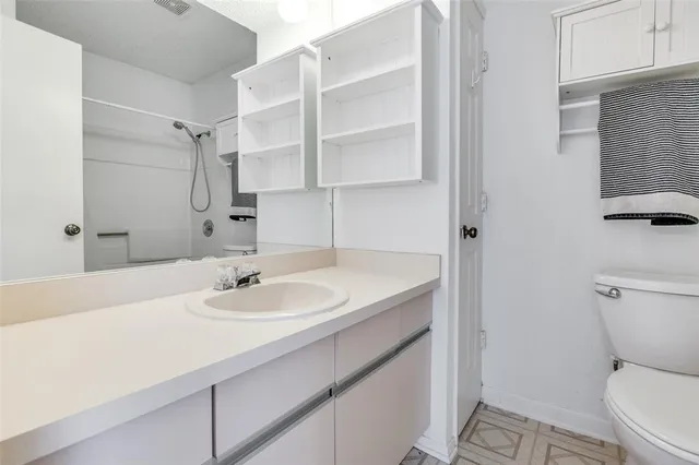 a bathroom with a sink toilet vanity and shower