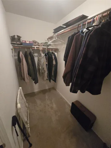 a view of walk in closet with clothes and shoes