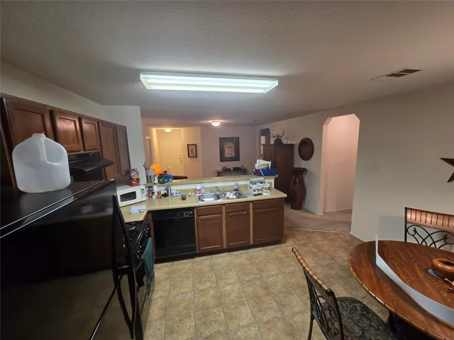 a large kitchen with kitchen island a stove a sink a dining table and chairs