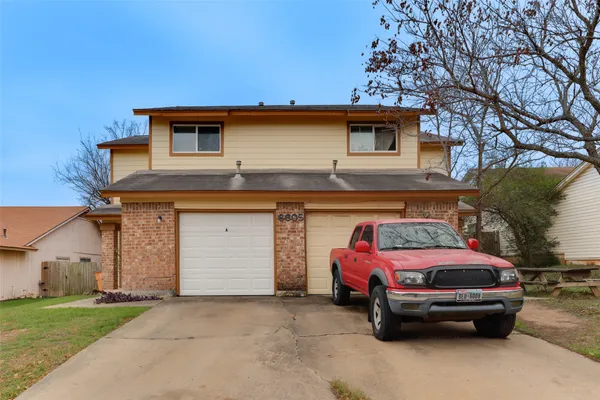 a front view of a house with parking space
