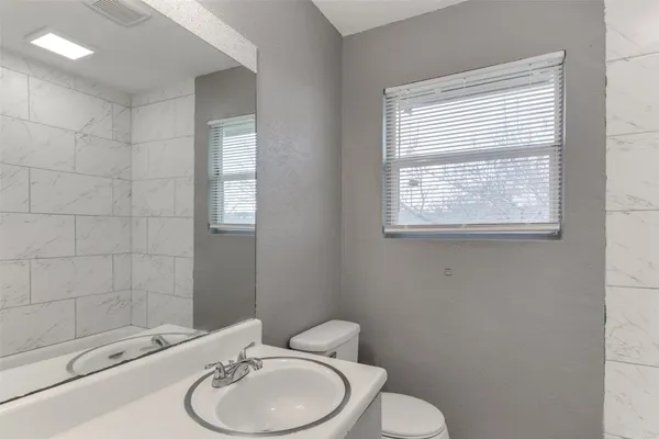 a white toilet sitting next to a bathroom sink
