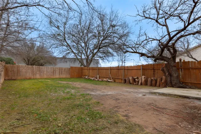 a view of a yard with a house and a large tree