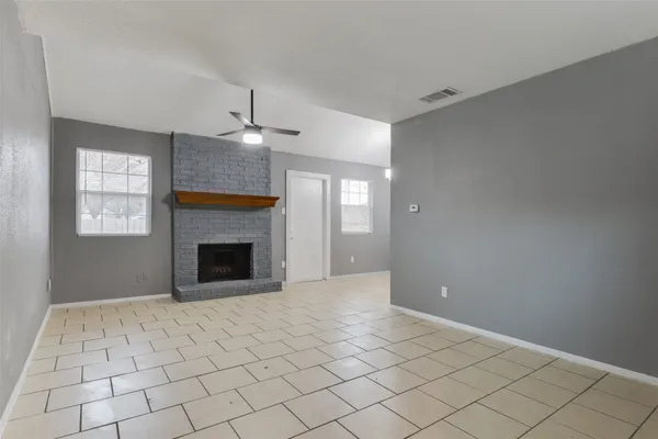 a view of an empty room with window and fire place