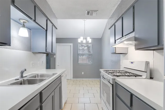 a kitchen that has a sink stainless steel appliances and cabinets