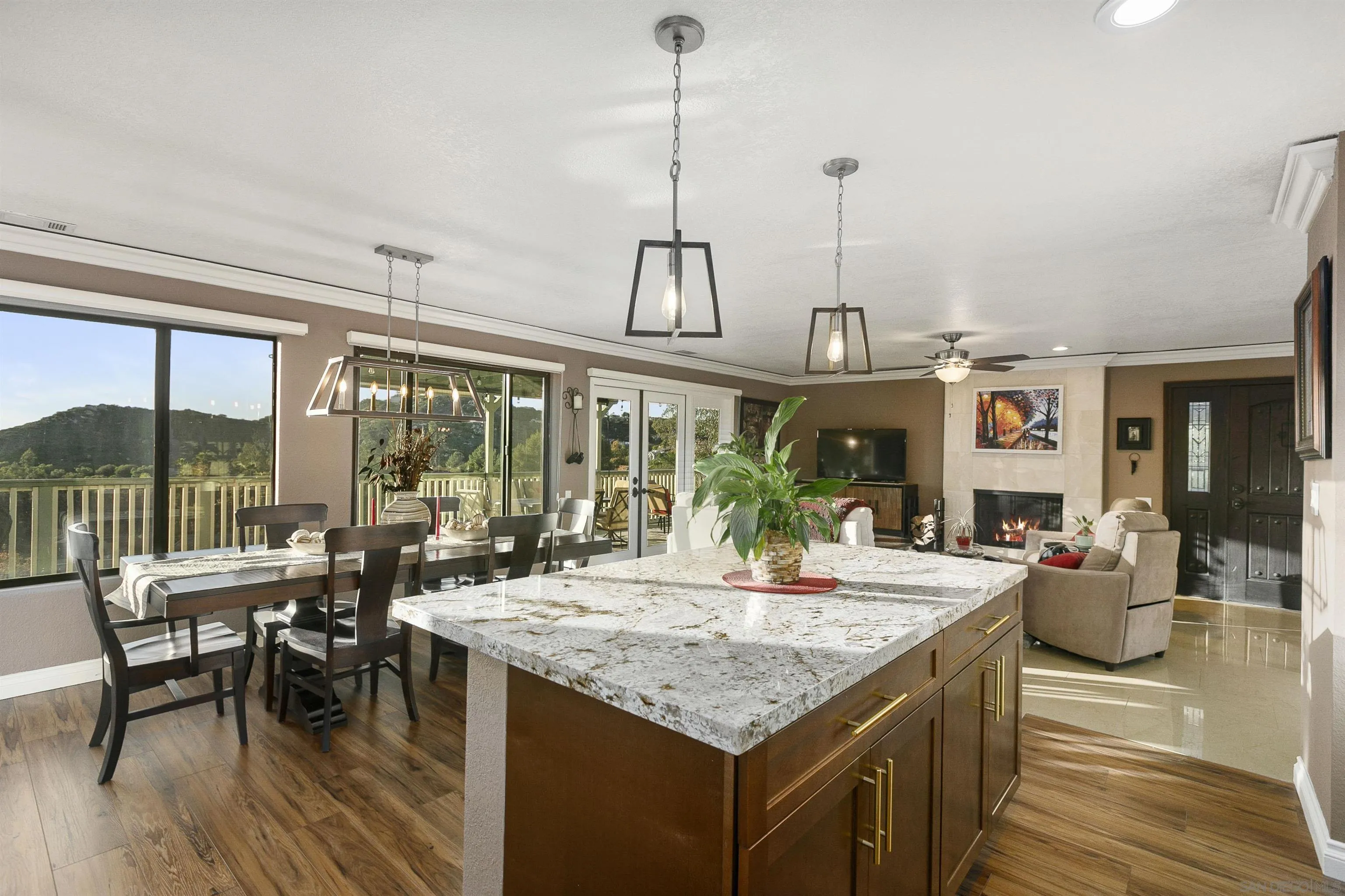2505 Suncrest Boulevard El Cajon, CA 92021 - Photo 2 of 45 a view of an dining room and livingroom with furniture wooden floor a rug a fireplace and a chandelier