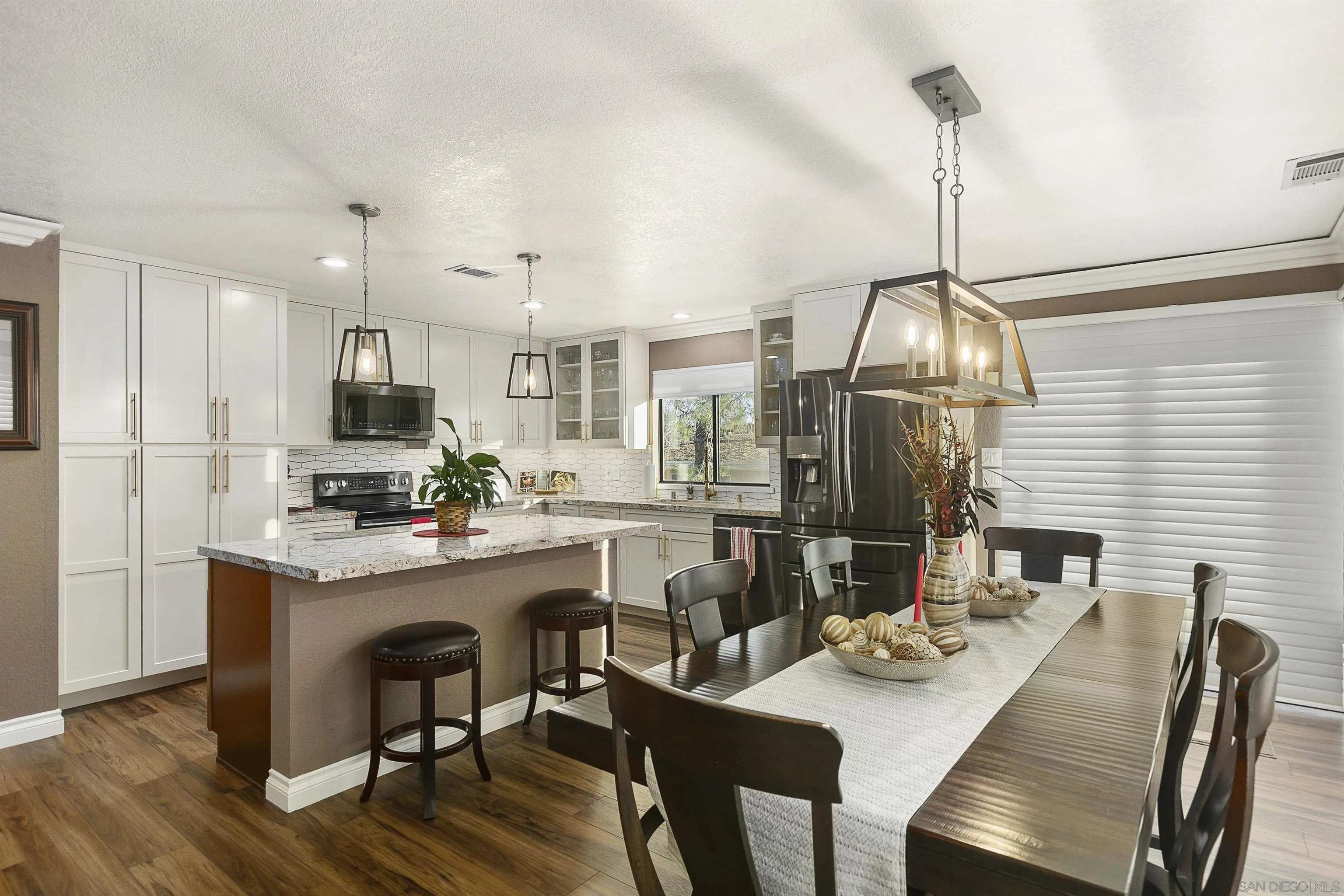 2505 Suncrest Boulevard El Cajon, CA 92021 - Photo 8 of 45 a kitchen with kitchen island a dining table chairs stainless steel appliances and cabinets