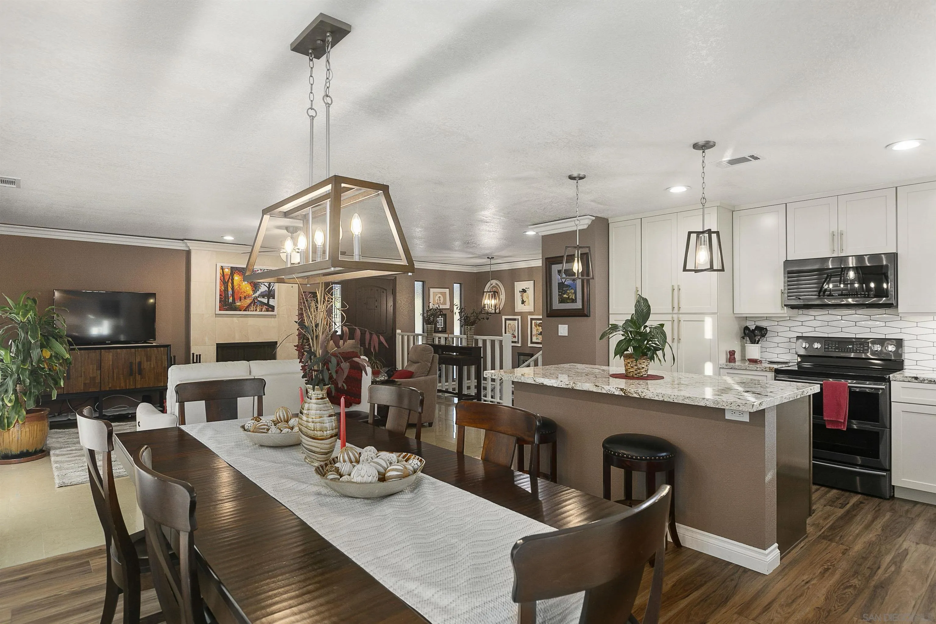 2505 Suncrest Boulevard El Cajon, CA 92021 - Photo 9 of 45 a kitchen with stainless steel appliances granite countertop a stove a refrigerator a kitchen island a dining table and chairs