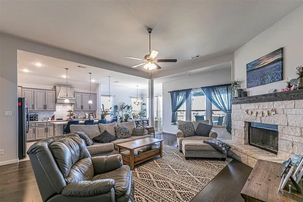 a living room with furniture kitchen view and a chandelier