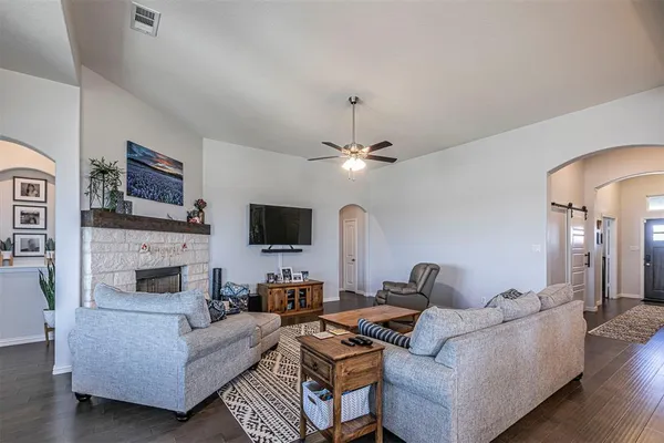 a kitchen with stainless steel appliances granite countertop a sink a stove a refrigerator and island with wooden floor