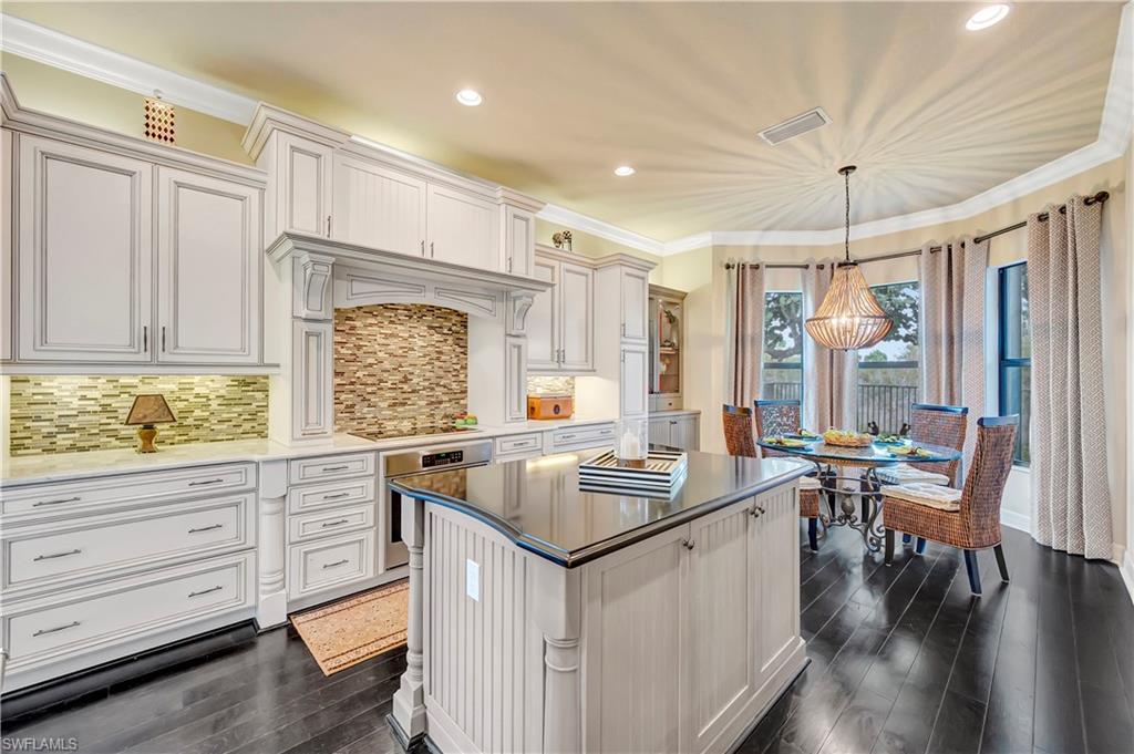3200 Atlantic Circle Naples, FL 34119 - Photo 17 of 41 a kitchen that has a lot of cabinets in it and wooden floors