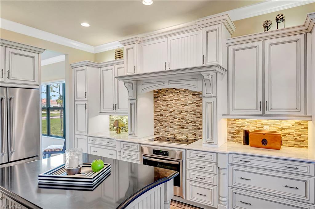 3200 Atlantic Circle Naples, FL 34119 - Photo 18 of 41 a kitchen with kitchen island granite countertop a stove and white cabinets