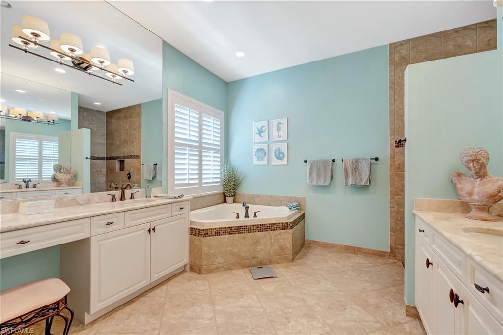3200 Atlantic Circle Naples, FL 34119 - Photo 27 of 41 a spacious bathroom with a sink a large mirror and a bathtub