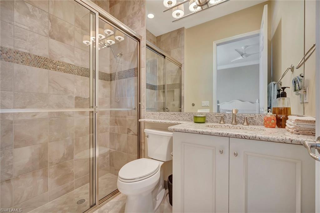 3200 Atlantic Circle Naples, FL 34119 - Photo 29 of 41 a bathroom with a granite countertop sink a toilet and shower