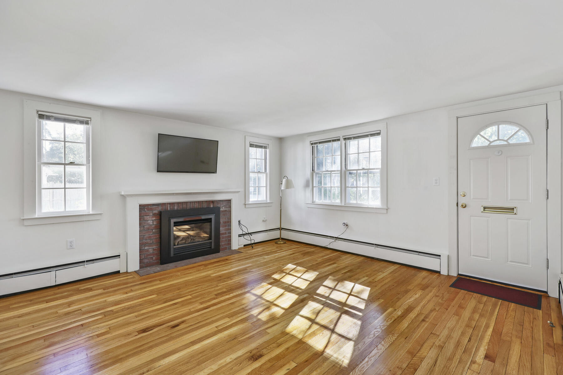 30 Davis Road Falmouth, MA 02540 - Photo 14 of 38 an empty room with windows fireplace and wooden floor