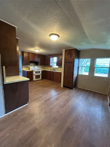 a kitchen with a refrigerator and a wooden cabinets