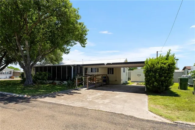 a view of house with a yard and potted plants