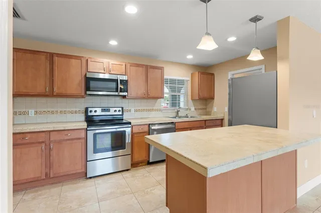 a kitchen with stainless steel appliances a stove a sink and a microwave