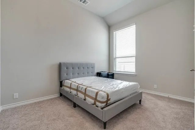 a bed sitting in a bedroom next to a window