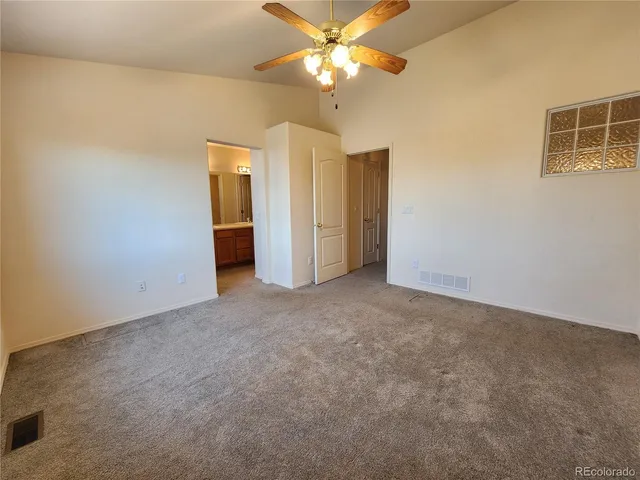 a view of a big room with windows and chandelier fan