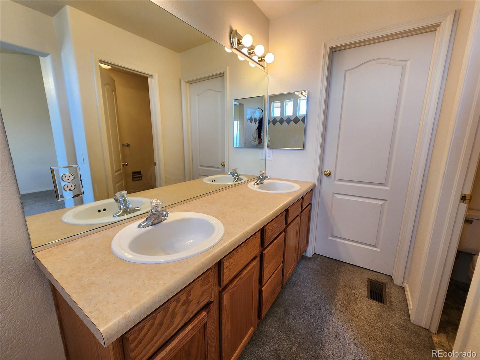 7022 Sand Crest View Colorado Springs, CO 80923 - Photo 15 of 16 a bathroom with a sink and a mirror