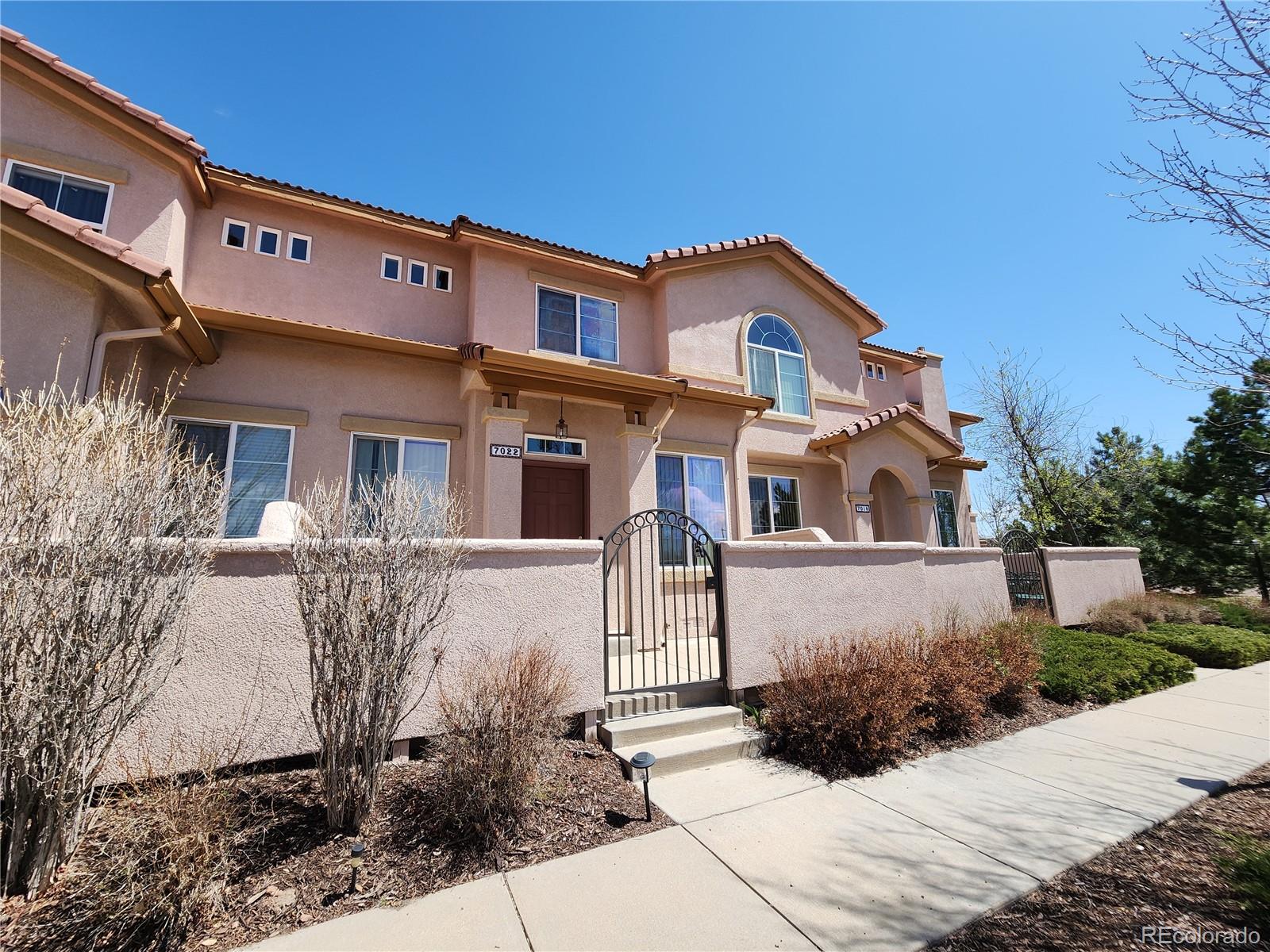 7022 Sand Crest View Colorado Springs, CO 80923 - Photo 2 of 16 a front view of a house with a yard