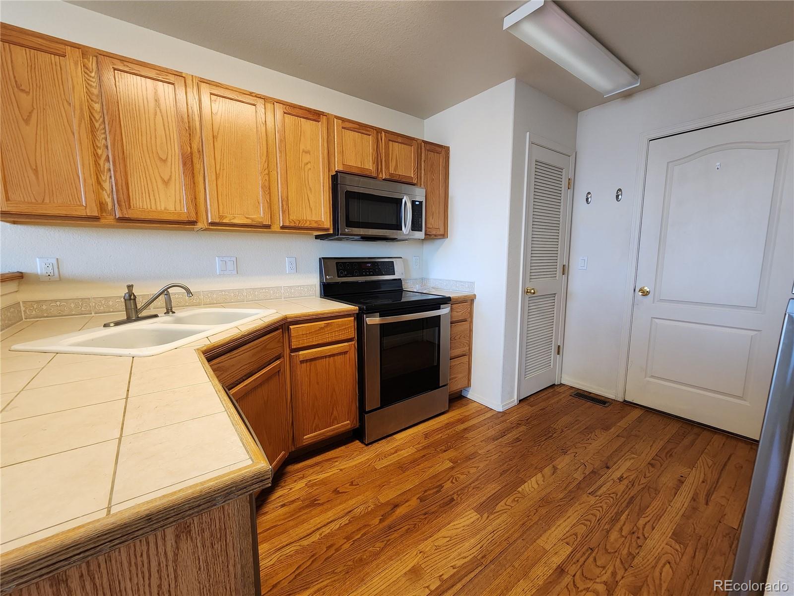 7022 Sand Crest View Colorado Springs, CO 80923 - Photo 7 of 16 a kitchen with a sink a stove and a microwave
