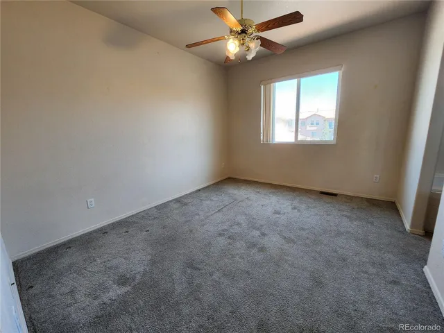 an empty room with a window and a fan
