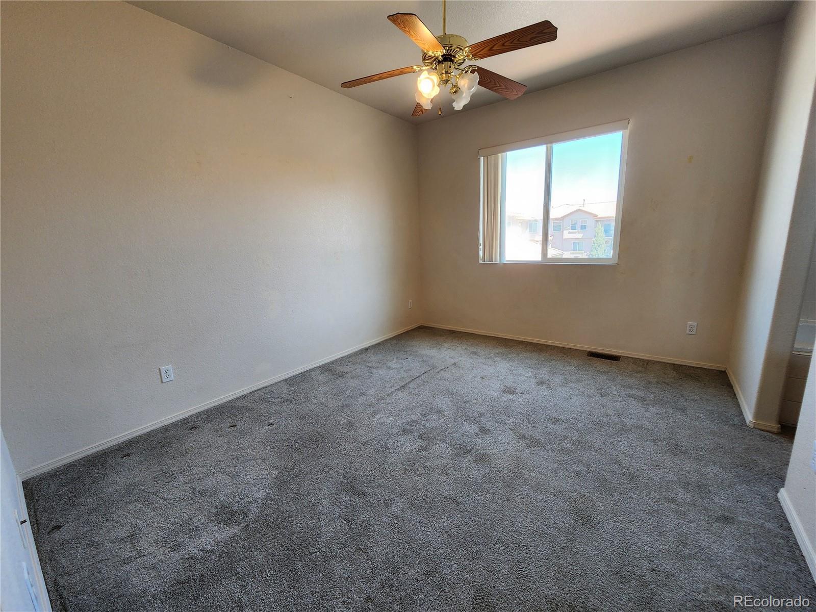 7022 Sand Crest View Colorado Springs, CO 80923 - Photo 8 of 16 an empty room with a window and a fan