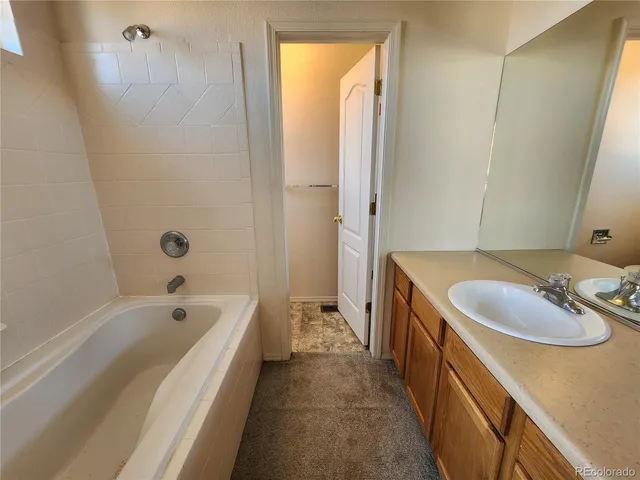 a spacious bathroom with a tub sink and mirror