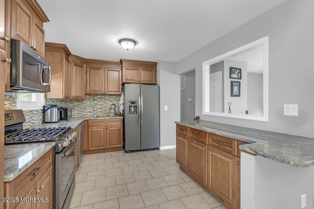 117 Manhattan Street Jackson, NJ 08527 - Photo 11 of 31 a kitchen with stainless steel appliances granite countertop a stove a sink and a refrigerator