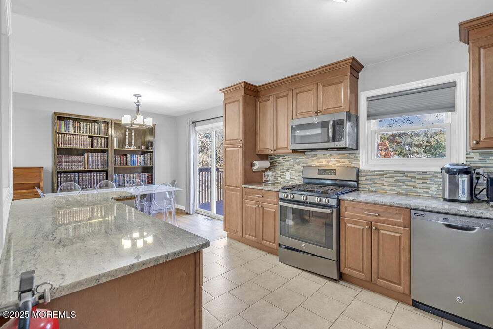 117 Manhattan Street Jackson, NJ 08527 - Photo 12 of 31 a kitchen with stainless steel appliances granite countertop a stove top oven a sink a counter space and cabinets